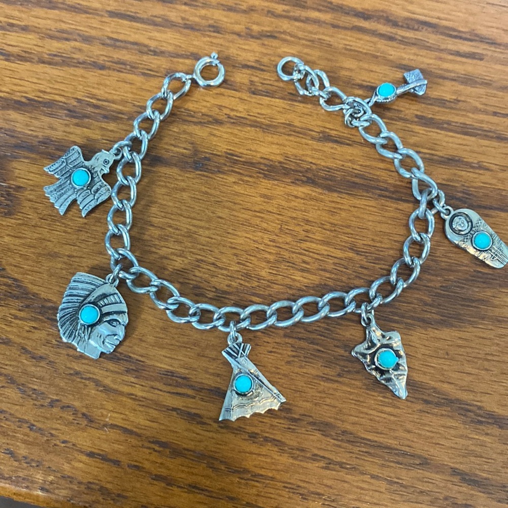 Clasp Bracelet with 6 Native American designs, with a turquoise color “gem”